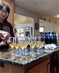 Zhuoyu Wang preparing wine glasses for sampling wines