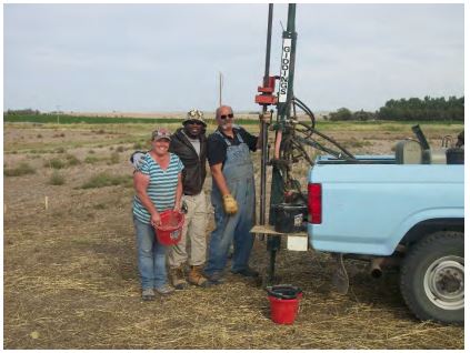 Three people standing with the WTARC soil sampler. 